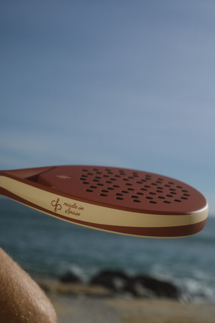 Terracotta Clima racket with its made in Spain script, by the sea