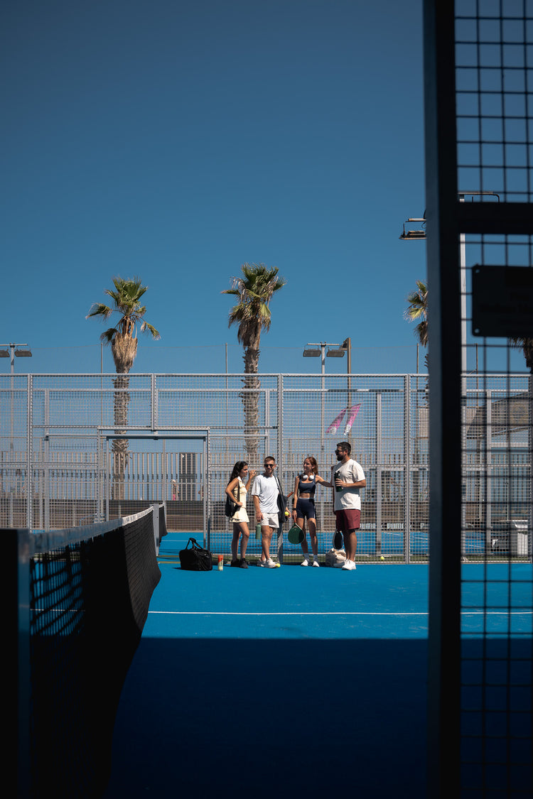 Four friends chatting on court under the palms